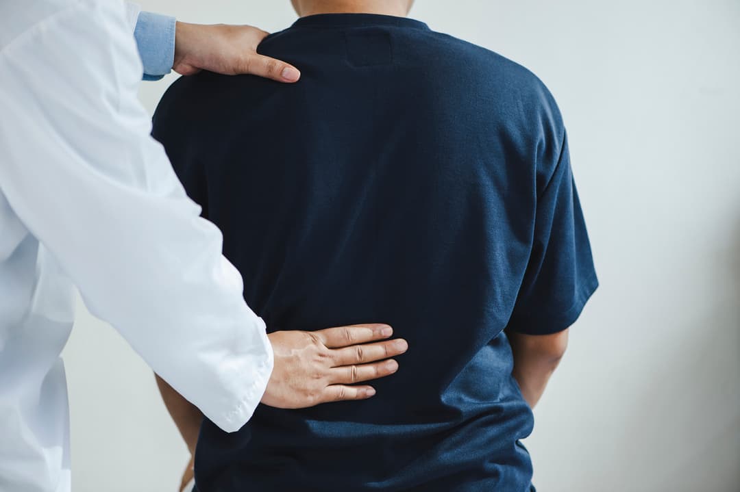 Closeup of a male Doctor or physiotherapist doing stretching for a patient in the clinic for examining treating injured of back stock photo