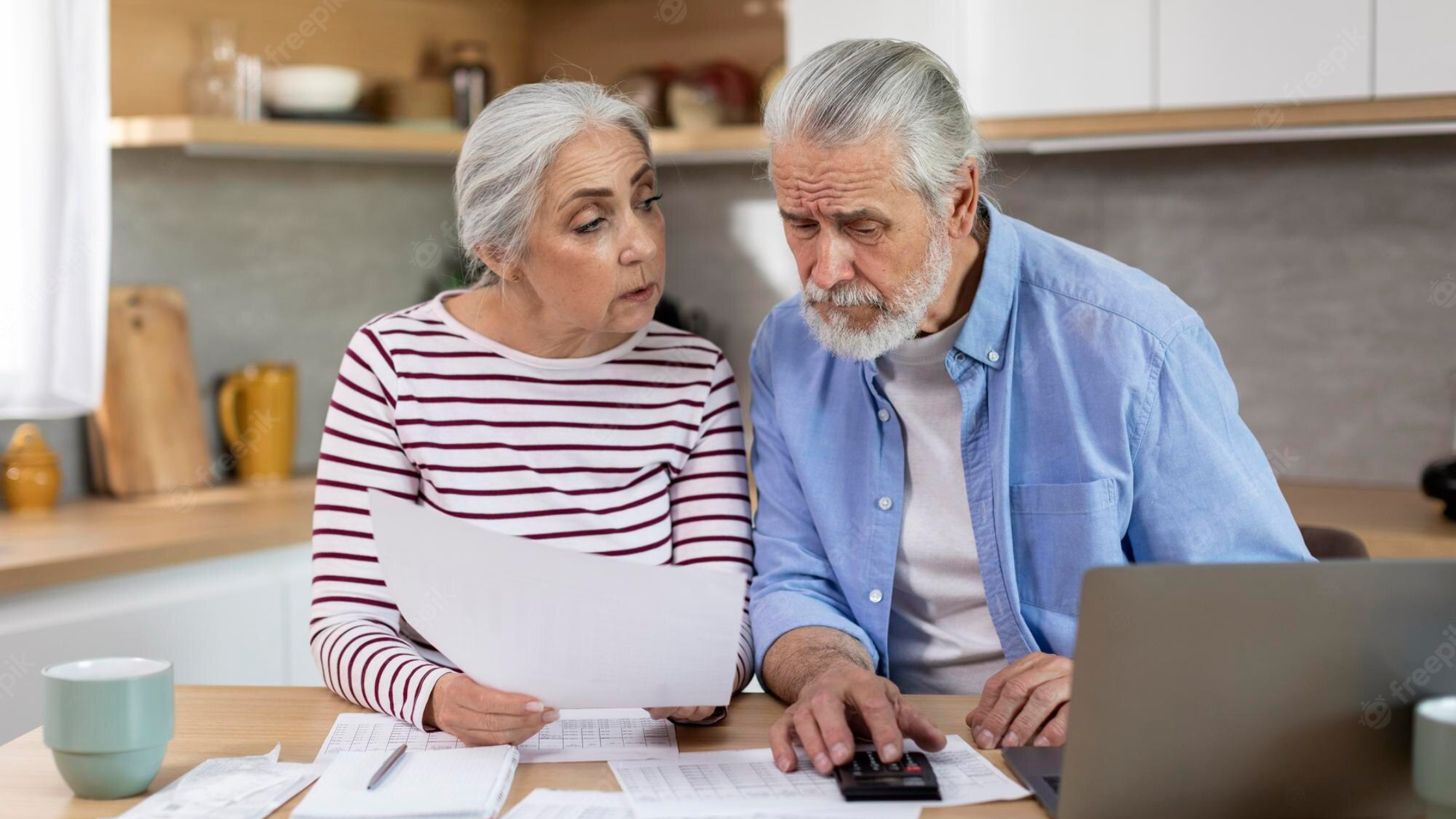 Senior couple going over their finances in front of a computer stock image