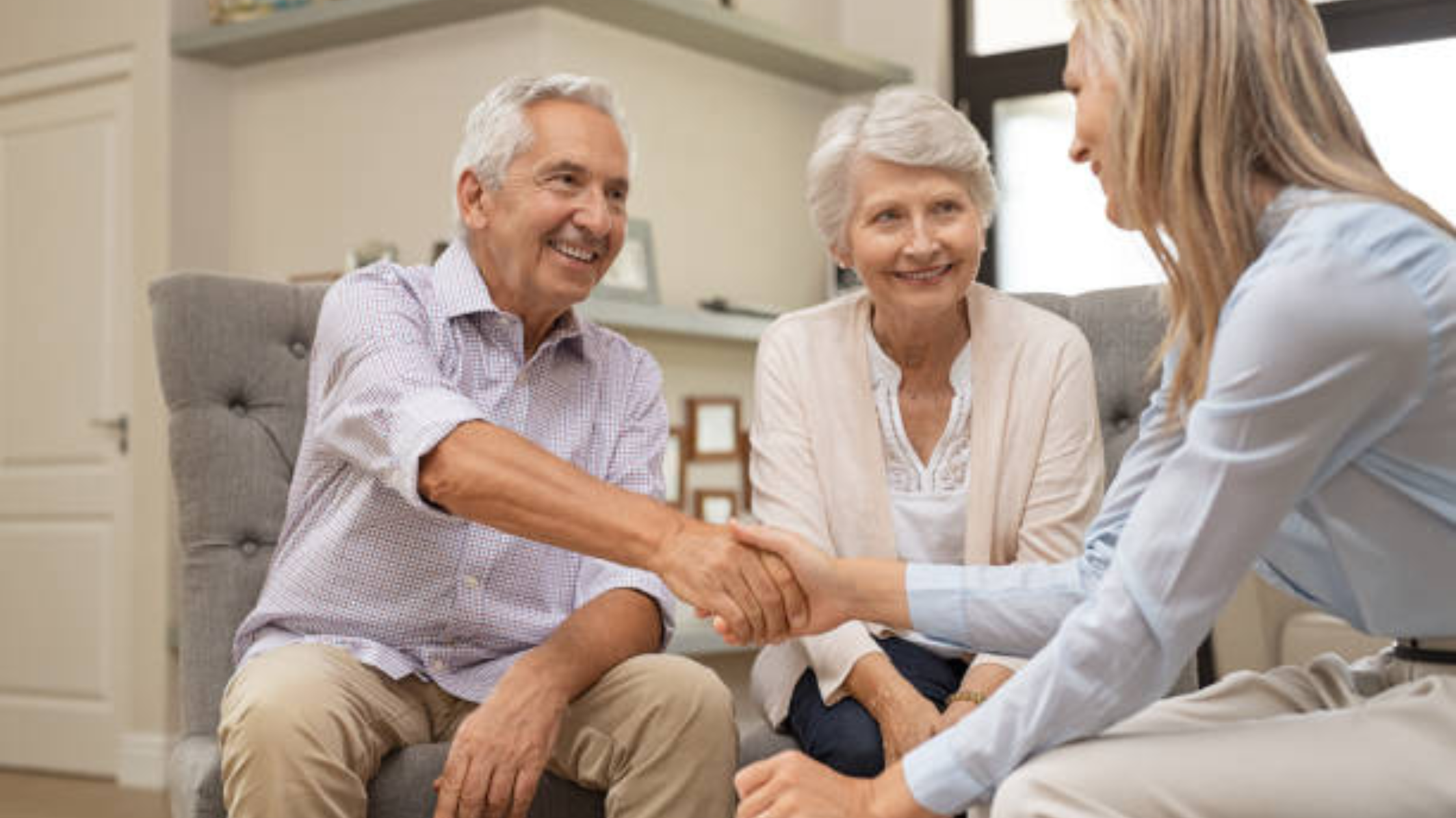 An elderly couple discusses their healthcare and insurance needs with another woman stock image