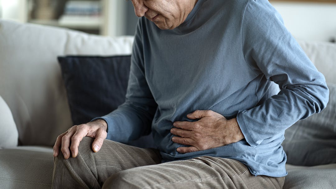 older man suffering from stomach pain due to IBS stock photo