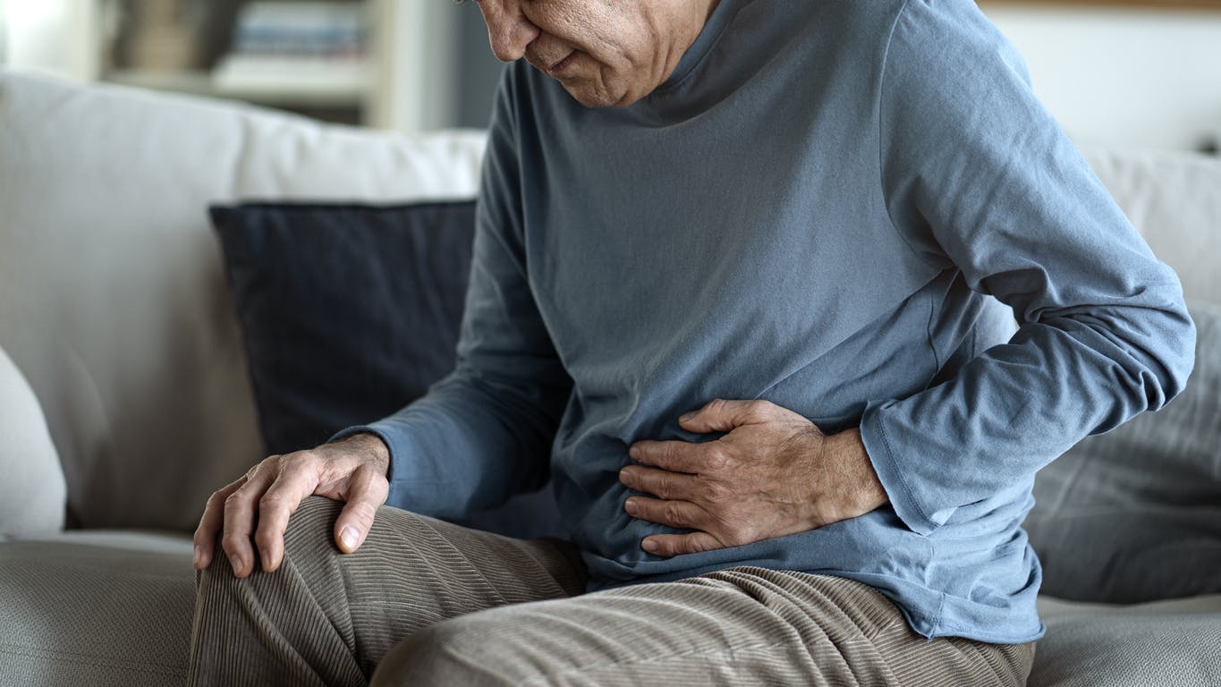 older man suffering from stomach pain due to IBS stock photo