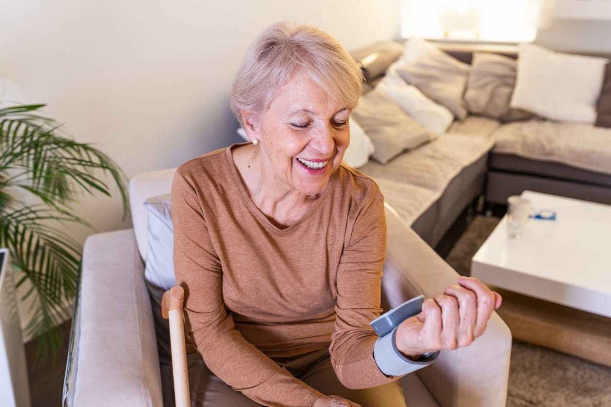 Senior woman checking blood pressure/heart rate at home stock photo