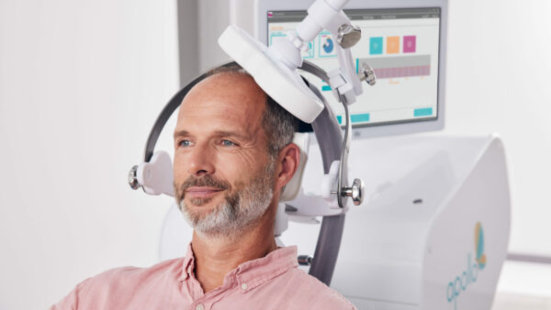 smiling man receiving TMS therapy stock photo