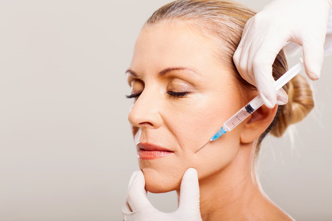 senior woman doing botox stock photo