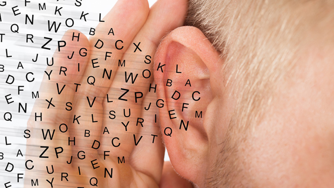 senior man reaching to his ear with jumbled letters going into the ear stock image