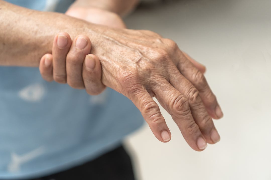 Close up of a senior clutching their right wrist in pain stock photo