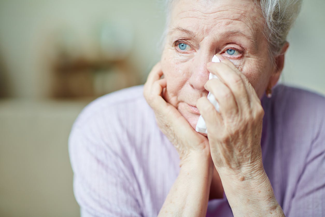 Upset senior woman crying stock photo