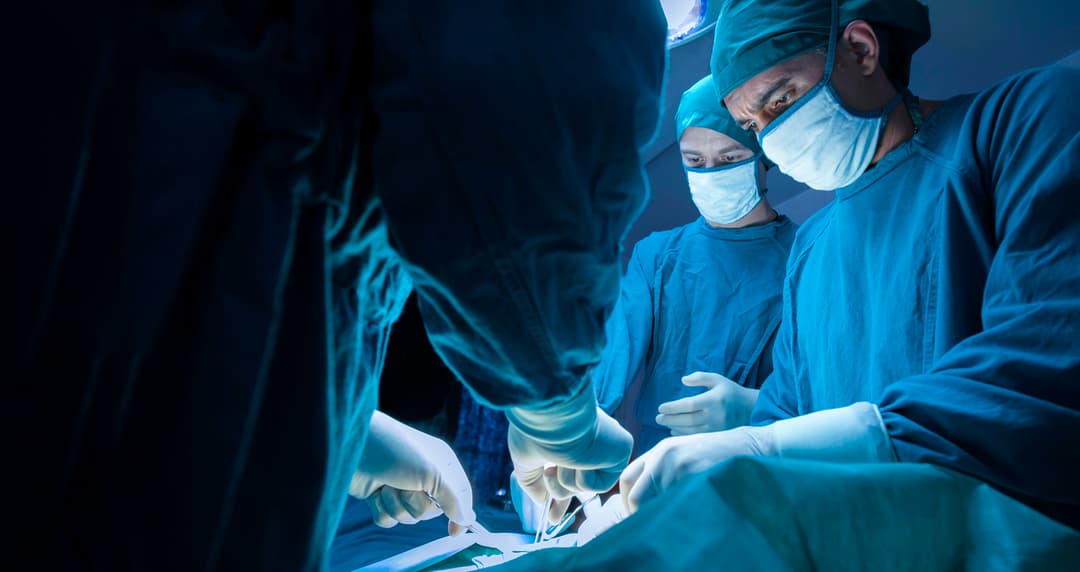 surgeons working over a patient stock image