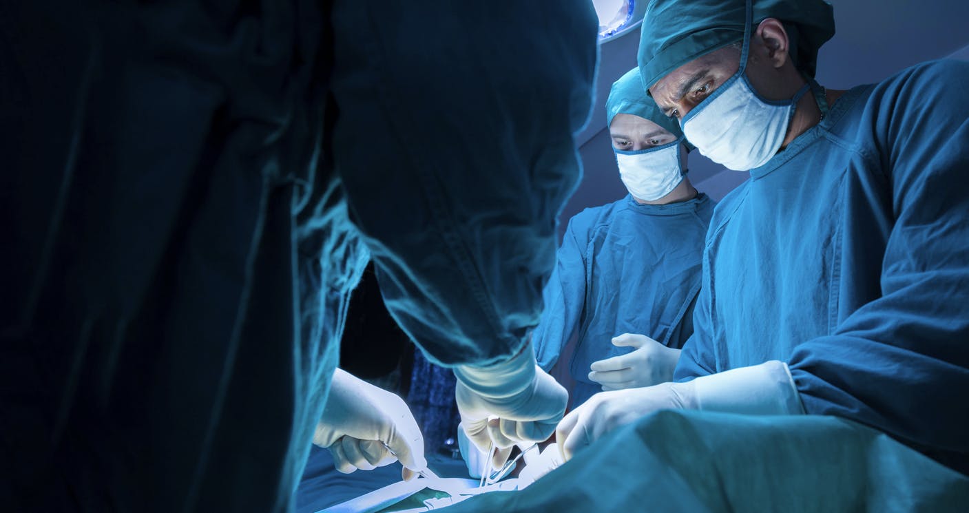 surgeons working over a patient stock image