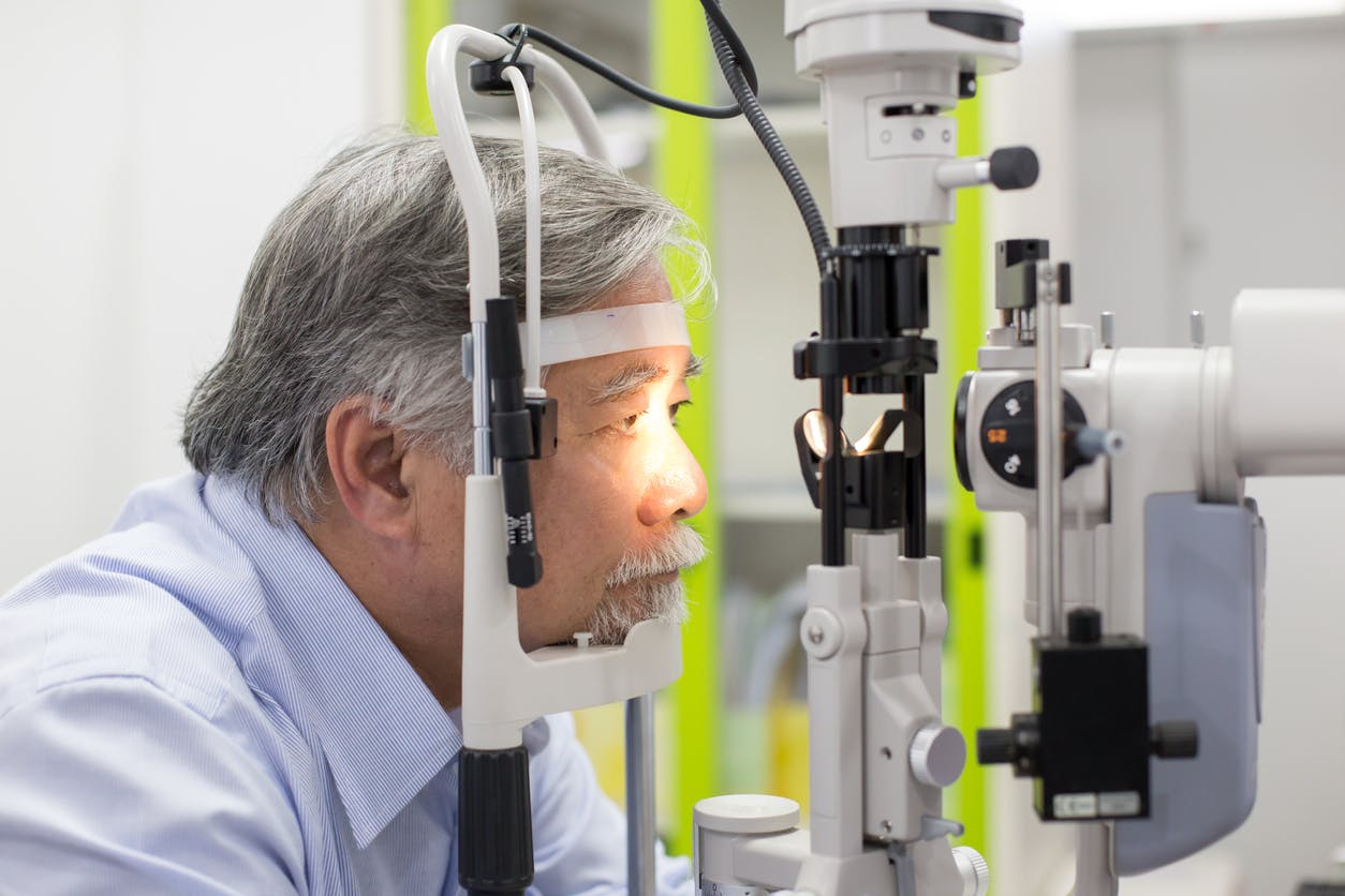 Asian senior male patient having him eyes examined by laser machine